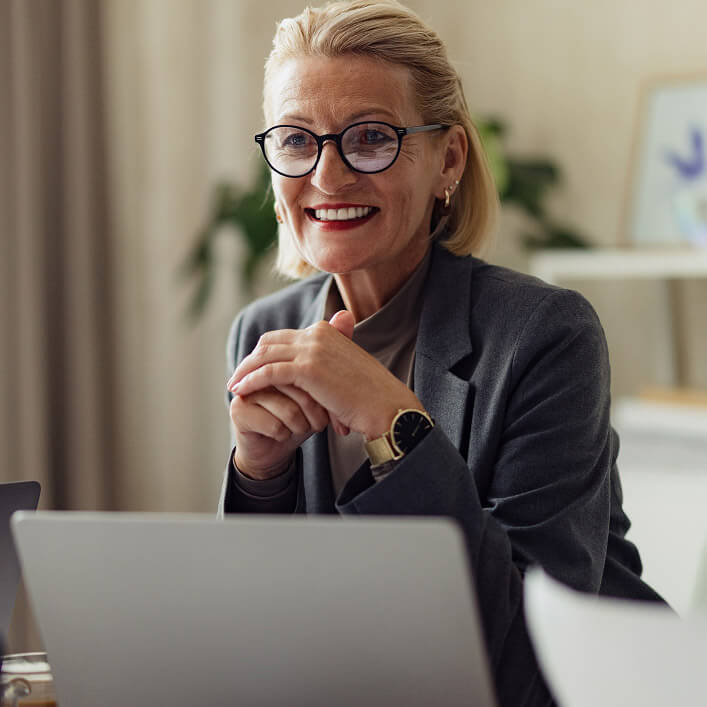 Woman smiling in front of laptop