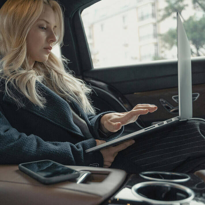 Woman using laptop in car