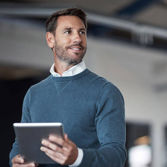 Man smiling holding tablet